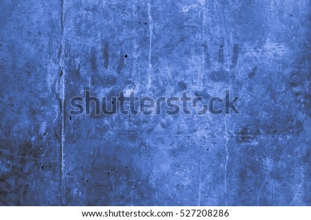 playful colorful children's hand impressions on a blue light grayish bluish indigo concrete wall. Fine artistic backgrounds of almost gray resulting from various rough construction materials, gesture.