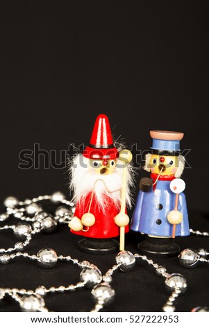  carolers ,christmas decorations ,black background ,red ,blue. singing ,ornaments ,vintage ,style ,woman ,man ,old