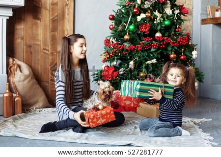 Happy children unpack gifts for Christmas. The concept of Christmas and New Year.