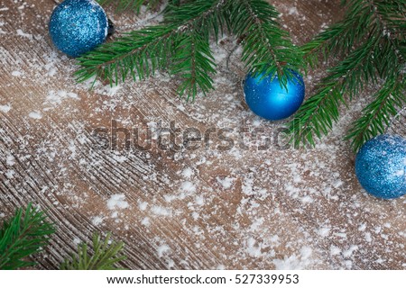 Christmas and New Year winter holiday snowbound wooden space background with green fir tree branches and blue ball ornament