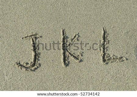 alphabet letters j k l handwritten in sand on beach Royalty-Free Stock Photo #52734142