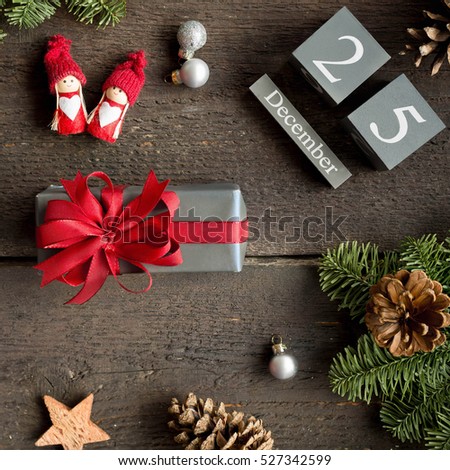 Christmas present with red ribbon, christmas calendar, pine branches, cone and xmas decorations. Christmas concept.