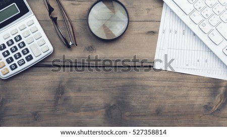 keyboard,magnifier,calculator and documents on table