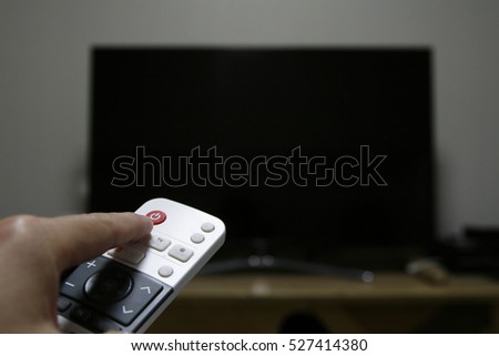Hand holding remote control 
