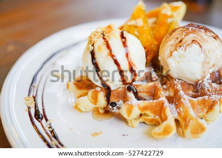 Fresh waffles with ice cream and maple syrup on a wooden background, Food and Dessert background concept