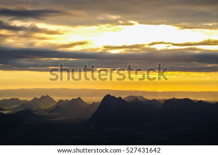 Beautiful Mountain And Sunset. Dark Silhouette of Mountains on Yellow Sunrise Background selective focus