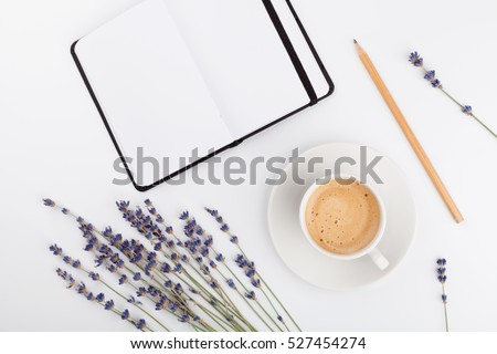 Coffee, clean notebook and lavender flower on white  background from above. Woman working desk. Cozy breakfast. Mockup. Flat lay style