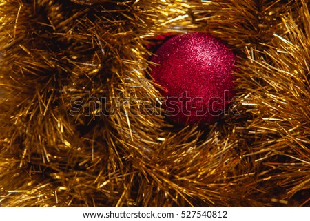 Minimalist Christmas decorations in two colors: red and gold balls with shiny yellow tinsel. New year background.