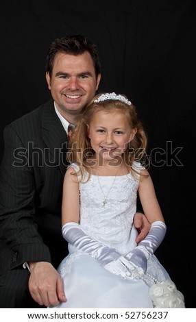 father and daughter close up portrait on black background. daddy and girl first holy communion . father in suit and daughter in white lace dress with gloves .