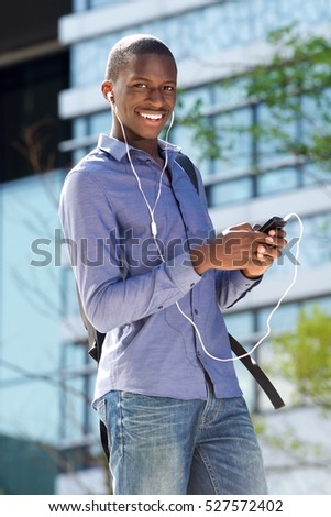 Portrait of young african american man listening music on his cell phone