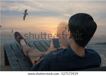 Double exposure of Back side view of man relaxing on the beach outdoors background using smartphone, luxury relaxation concept