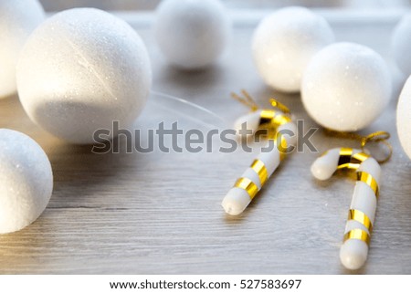 many small white balls toys symbol of the new year on wooden background with purple stars, tinsel, top view, there is a place for the text as a background and substrate
