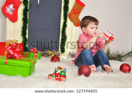 Little boy plays with Christmas decorations and wait a New Year