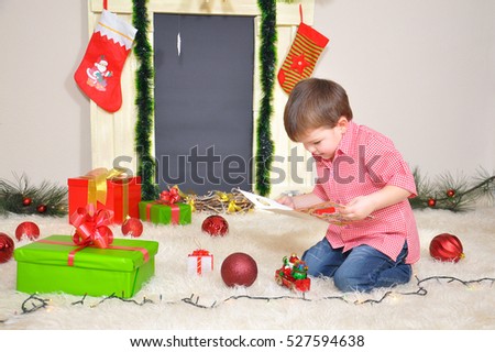 Little boy reading a musical greeting card for a Christmas. New year's musical greeting card