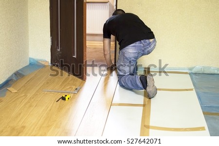 The process of installing laminate wooden on the floor of in the green room