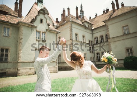 Just married poses and kissing with an old fortress on the background