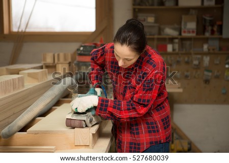 Carpenter  woman doing his job in carpentry workshop.
