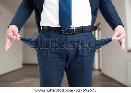Closeup of male realtor showing his empty suit pockets as bankruptcy concept Royalty-Free Stock Photo #527692675