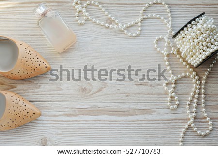 purple shoes, perfume and beads on the table. Concept of femininity and beauty
