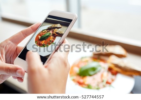 food, eating, technology, culinary and people concept - woman hands with gazpacho soup photo on smartphone screen at restaurant