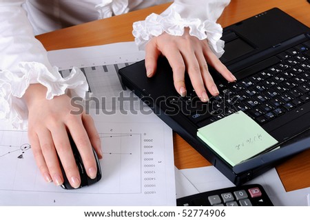 hand of a young business woman working for a laptop. Workplace of business people.
