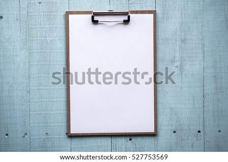 Clipboard with white sheet on wood background. Top view. mock up for word. Royalty-Free Stock Photo #527753569