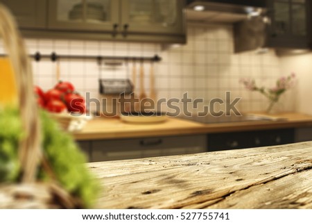 Wooden table of free space in kitchen and blurred vegetables 