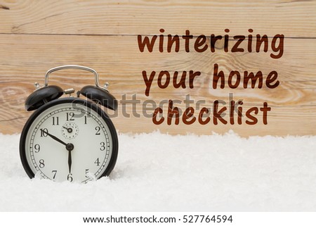 Prepare for winter message, Some snow and an alarm clock on weathered wood with text Winterize your home checklist Royalty-Free Stock Photo #527764594