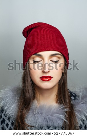Winter style. Sweet girl in the red hat and closed eyes. Passion and expression