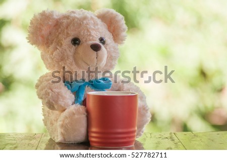 Teddy bear relaxes with red coffee cup  on wooden table , Relax and freedom concept