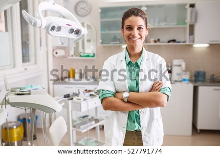 Portrait of  female dentist .She standing in her dentist office. Royalty-Free Stock Photo #527791774