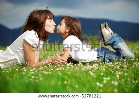 Happy young mother with daughter resting outdoors