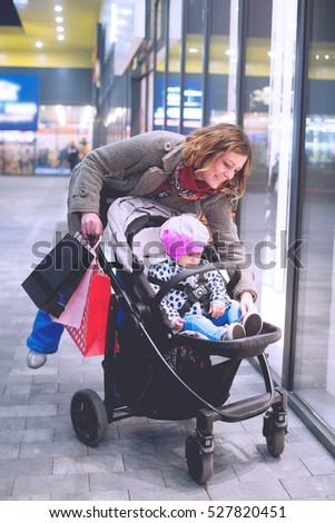Young woman with her child in shopping.Colored photo