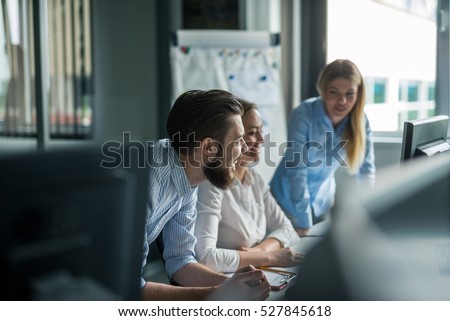 Team of colleagues brainstorming together while working on the computer. Royalty-Free Stock Photo #527845618