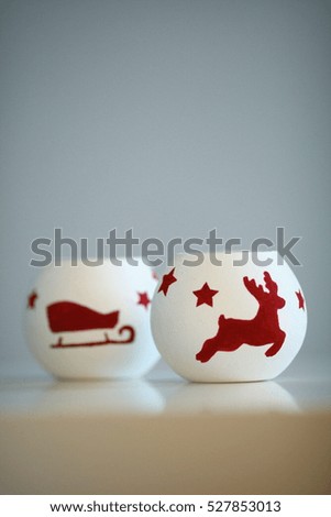 Christmas candles with deer and sleds pictured on it