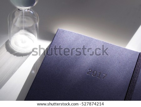 Diary for 2017 and a sandglass (selective focus)