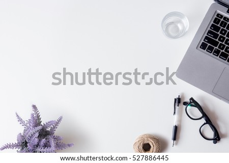 White office desk table with laptop, smartphone, pen, lavender, rope, and glass. Top view with copy space, flat lay.