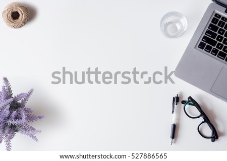 White office desk table with laptop, smartphone, pen, lavender, rope, and glass. Top view with copy space, flat lay.