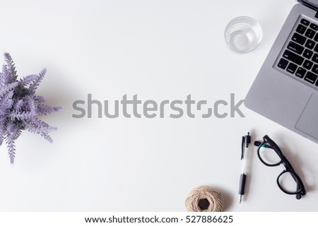 White office desk table with laptop, smartphone, pen, lavender and glass. Top view with copy space, flat lay.