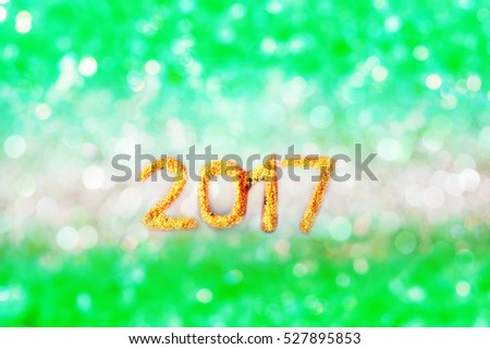 Abstract bokeh picture gold year 2017 on silver and green color of ice, Christmas decoration for background, greeting cards, happiness festival, New years wishes sent to everyone you love
