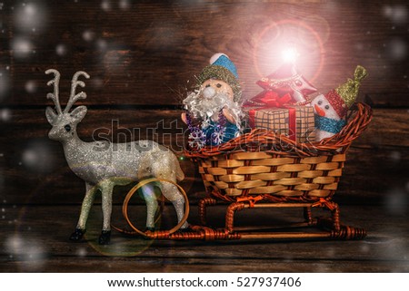 Santa and snowman in a reindeer sleigh with gifts.
