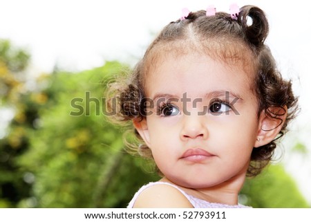 Baby looking up over green background. Outdoor image