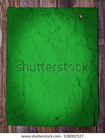 Blank page of old green vintage paper on wooden background