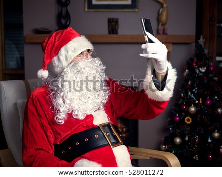 Santa claus using mobile phone taking a selfie