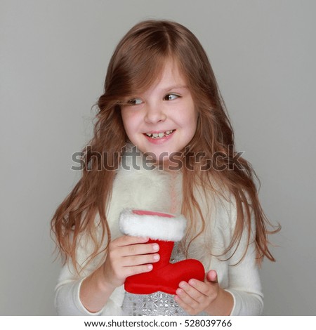 Cute smiling little girl with Christmas red boot/Christmas and New Year decoration