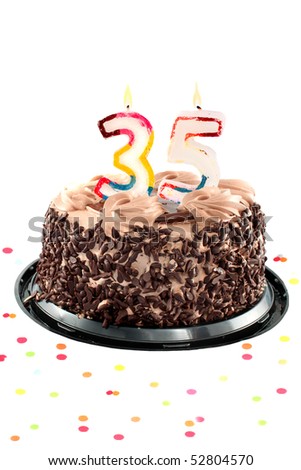 Chocolate birthday cake surrounded by confetti with lit candle for a thirty fifth birthday or anniversary celebration