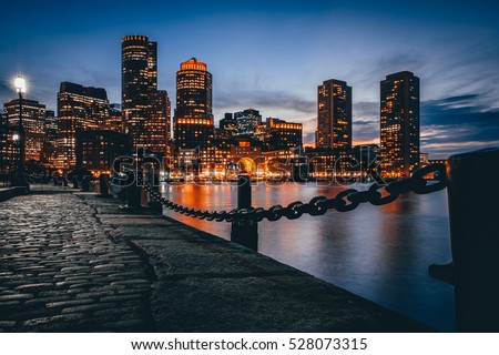 Boston downtown skyline with skyscrapers over water at twilight