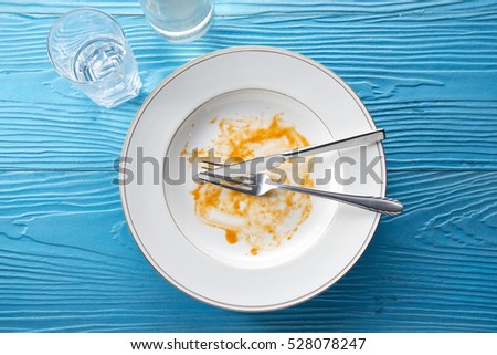 dirty and empty dishes on wooden table.
