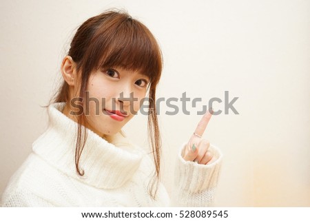 Young woman pointing something with white