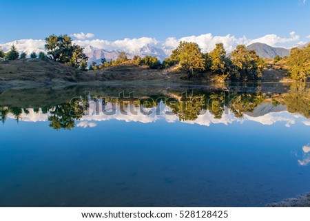 Mesmerizing view and reflections in Deoria Tal or Lake nestled in Garhwal Himalayas at  Chopta, Uttarakhand, India. This lake is a camping site for Tungnath Chandrashila hiking trail.